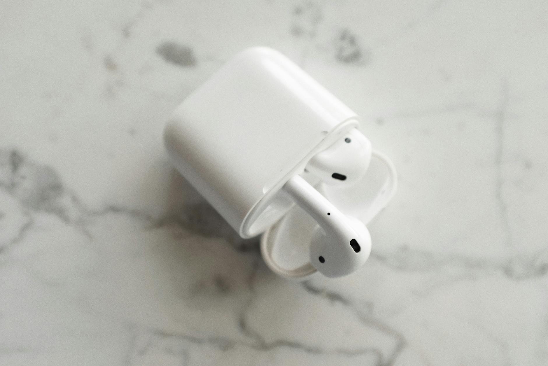 A top-view photo of wireless earbuds in a case, placed on a marble surface, showcasing modern technology.