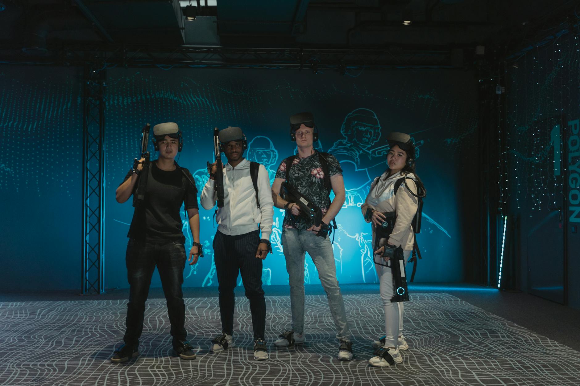 A diverse group of friends playing with VR headsets and guns in a gaming arena.